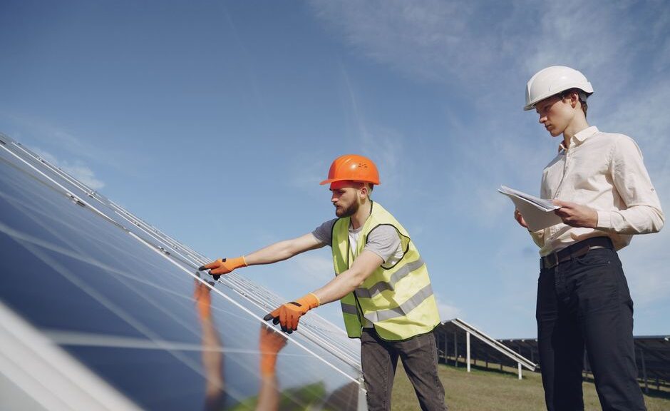 Een adviseur bespreekt energieoplossingen zoals zonnepanelen en laadpalen met een huiseigenaar voor een duurzame toekomst.